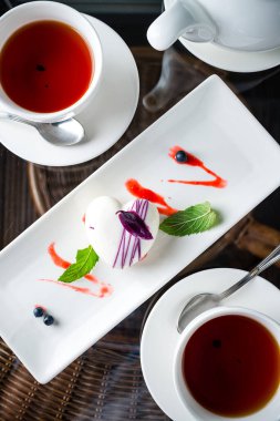 Kremalı pasta, Fransız tatlısı, çay, iki küçük top şeklinde kek, köpük kubbesi çay bardağında servis edilir.