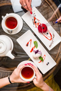 İki bayan arkadaş kremalı pasta yiyor Fransız tatlısını yiyor ve bir kafede çay içiyor, kremalı tatlı yiyor bir arkadaşla kafede kahvaltı yapıyor.