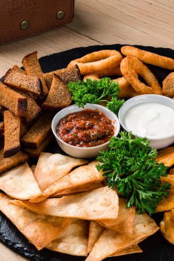 Bira atıştırmalıkları, kombo atıştırmalıkları bira aperatifleri, kızarmış ekmekler. Deef Fried Chicken Nuggets, Cheese Fingers, soğan halkaları ahşap masada tempura.