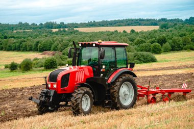 Traktörlü çiftçi sonbaharda toprağı sürüyor.