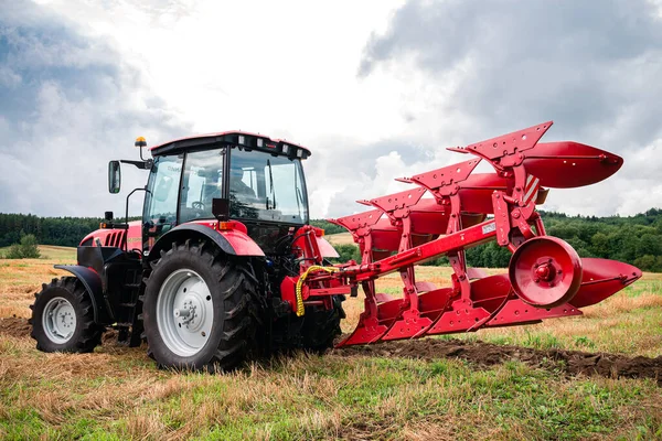 Traktor mit großem Pflug ist bereit für die Feldarbeit — Stockfoto