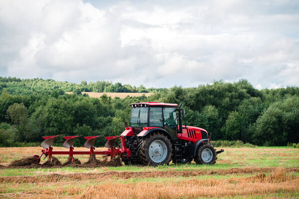 Farmer in tractor plowing the land in autumn