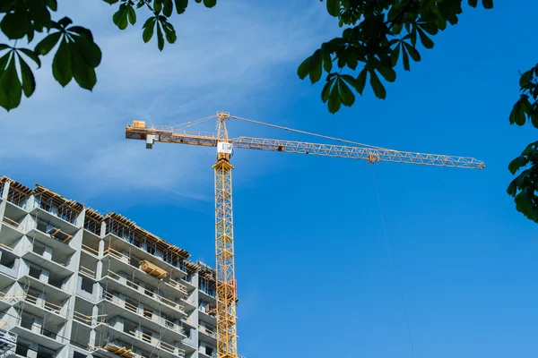 Crane and building construction against blue sky — Stock Photo, Image