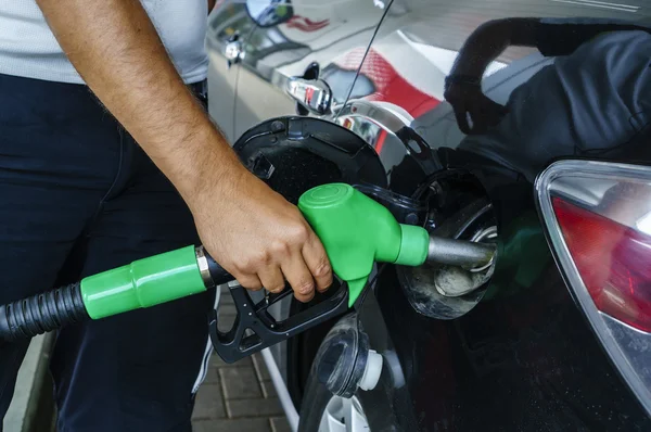 Man refueling his car in a gas station. Focus on filling nozzles Stock Image