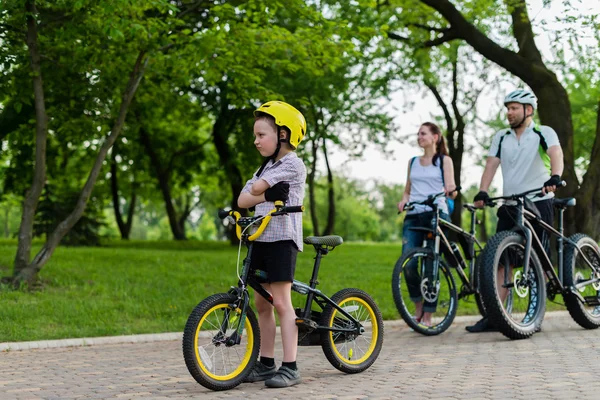 5-jähriger Junge sitzt auf seinem Fahrrad vor seiner Familie — Stockfoto