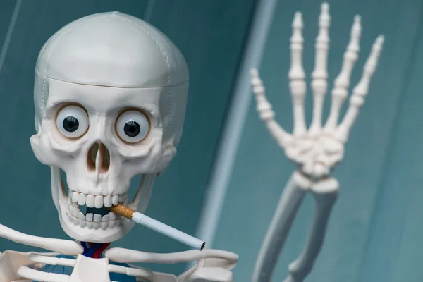 Skeleton smoking cigarette. Focus on cigarette — Φωτογραφία Αρχείου