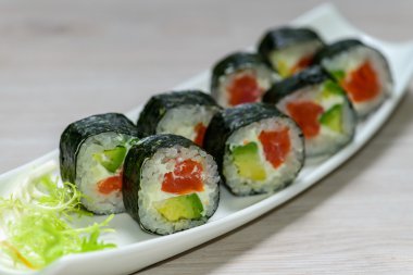 Yakın çekim Maki sushi plaka üzerine sığ derinlik-in tarla düzenlenmiş,