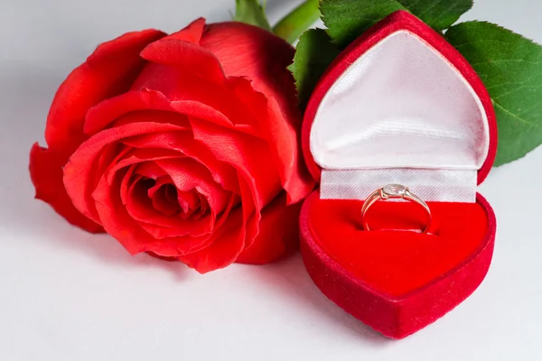 Golden engagement ring in a heart shaped box and a flower rose — Stock Photo, Image