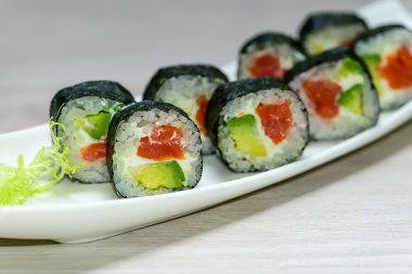 Yakın çekim Maki sushi plaka üzerine sığ derinlik-in tarla düzenlenmiş,