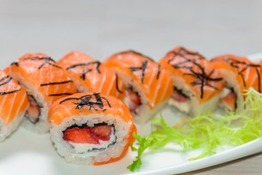 Suşi ile beyaz bir tabak Close-Up ayarla - strawber ile Somon