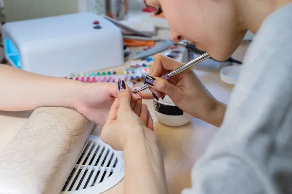 Manicurist at work, painting nails in nail salon, UV lap of quic — Stock Photo, Image