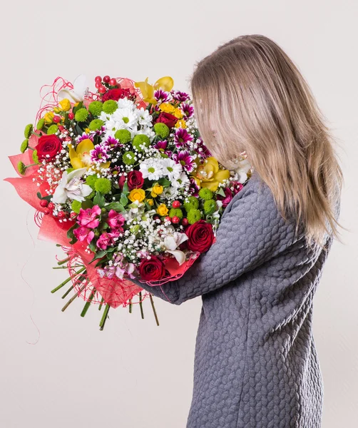 Mädchen mit braunen Haaren mit einem schönen Strauß in der Hand zurück zu th — Stockfoto