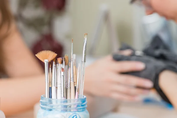 Brush close-up in nail salon, selective focus on the brush — Stock Photo, Image