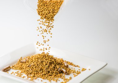 arı polen arı polen homeopatik ilaçlar (yakın çekim, sığ Dof beyaz plakalı akışında düşüyor)