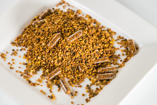 Крупный план некоторых гомеопатических таблеток с пчелиной пыльцой в рассеянном виде
 