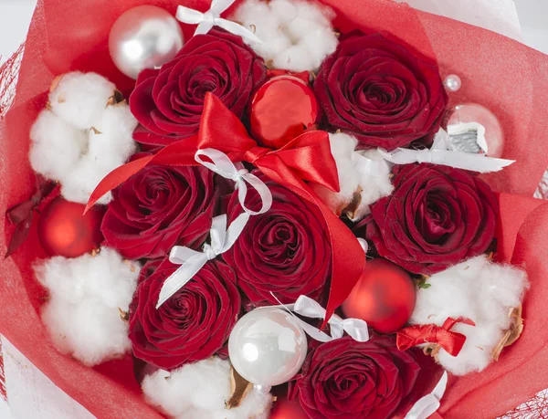 Nahaufnahme des weihnachtlichen Winterstraußes aus roter Rose und Baumwolle in der Verpackung. flacher dof — Stockfoto