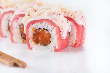 Yemek çubuklarını kapatın. Lokantada porsiyon suşi alın. Yemek çubuklarıyla suşi yiyin.