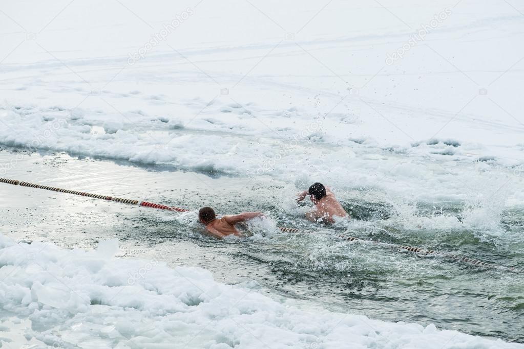 Ice swimming, swimming competitions in the winter outdoors at a frozen lake. Extreme fitness sport. — Stock Photo © smspsy #97201888