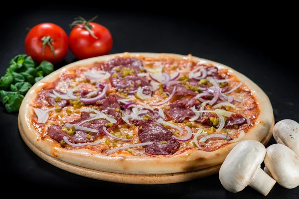 Zbliżenie smaczne pizze z pomidorami, serem, bazylia i szynki na bl — Zdjęcie stockowe