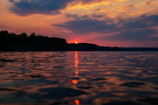 Solnedgång och reflektion med dramatisk himmel (tonad bild) — Stockfoto