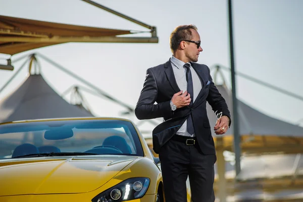 Succesvolle yang zakenman in gele cabrio auto — Stockfoto