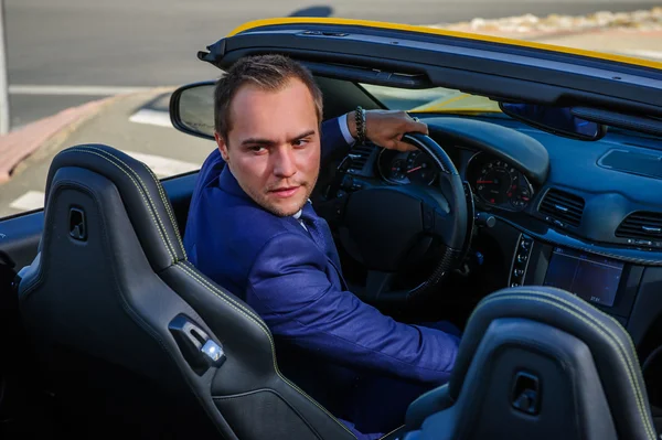 Succesvolle yang zakenman in gele cabrio auto. — Stockfoto