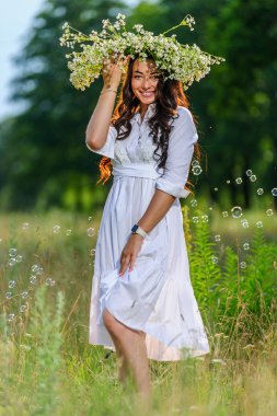 Onun baş pozlar doğanın arka planda üzerinde çelenk ile genç Slav kadın