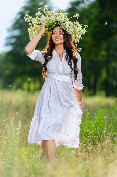 自然の背景に彼の頭のポーズに花輪を捧げる若いスラブ女性 — ストック写真