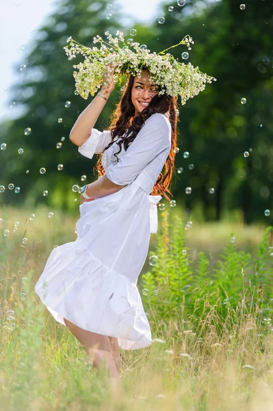 Giovane donna slava con ghirlanda sulla testa posa sullo sfondo della natura — Foto Stock