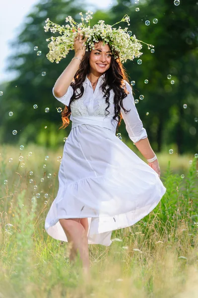 Junge slawische Frau mit Kranz auf dem Kopf posiert im Hintergrund der Natur — Stockfoto