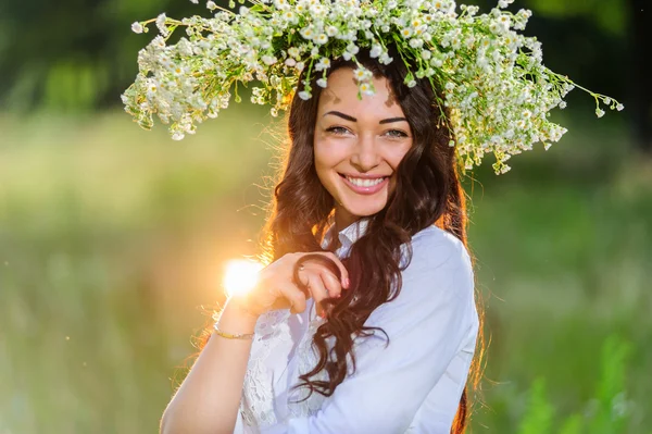 Slavische jonge vrouw met kroon op zijn hoofd houdingen in de achtergrond van de natuur — Stockfoto