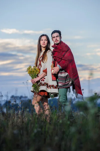 Hippie-mäßig gekleidetes Paar posiert im Morgenhimmel — Stockfoto