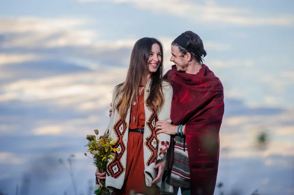Hippie-mäßig gekleidetes Paar posiert im Morgenhimmel — Stockfoto