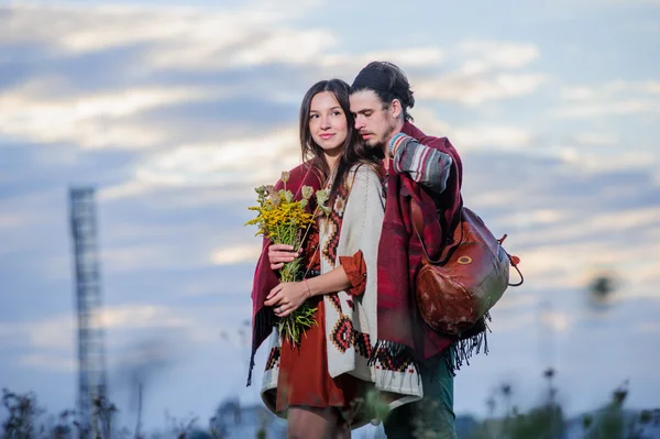 Hippie-mäßig gekleidetes Paar posiert im Morgenhimmel — Stockfoto