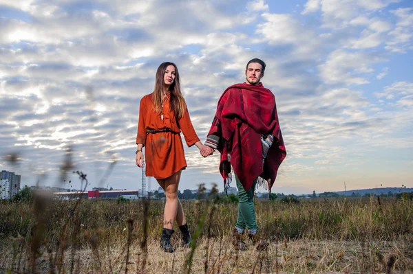 Hippie manera vestida pareja pose en la mañana cielo fondo — Foto de Stock