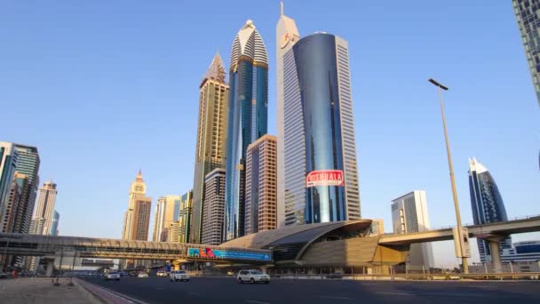 SHEIKH ZAYED ROAD IN DUBAI ,UNITED ARAB EMIRATES-MARCH 24, 2016: Busy Shaek Zayed Road, metro railway and modern skyscrapers around in luxury Dubai city,United Arab Emirates — Stock Video