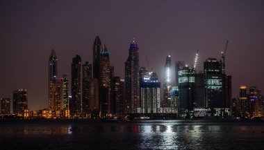 DUBAI, BAE - 17 DEC: Dubai Marina 'nın JBR - Jumeirah Beach Residence Kuleleri' nin 17 Aralık 2020 Dubai 'deki gece görüntüsü. Burası Arap Körfezi 'nden görünen muhteşem bir manzaranın sağ tarafı.