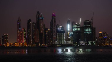 DUBAI, BAE - 17 DEC: Dubai Marina 'nın JBR - Jumeirah Beach Residence Kuleleri' nin 17 Aralık 2020 Dubai 'deki gece görüntüsü. Burası Arap Körfezi 'nden görünen muhteşem bir manzaranın sağ tarafı.