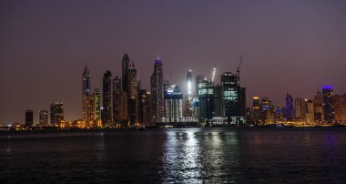 DUBAI, BAE - 17 DEC: Dubai Marina 'nın JBR - Jumeirah Beach Residence Kuleleri' nin 17 Aralık 2020 Dubai 'deki gece görüntüsü. Burası Arap Körfezi 'nden görünen muhteşem bir manzaranın sağ tarafı.