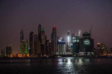 DUBAI, BAE - 17 DEC: Dubai Marina 'nın JBR - Jumeirah Beach Residence Kuleleri' nin 17 Aralık 2020 Dubai 'deki gece görüntüsü. Burası Arap Körfezi 'nden görünen muhteşem bir manzaranın sağ tarafı.
