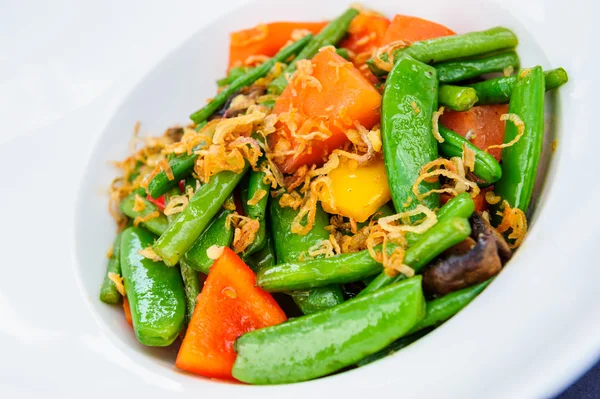 Plate of baked green beans mixed with pea pods and carrot. — Stock Photo, Image