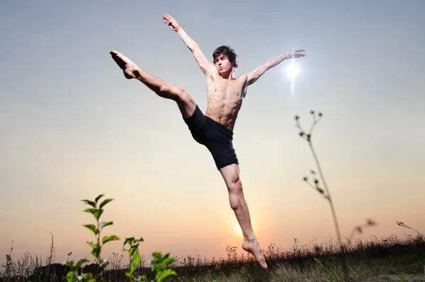 Yang αρσενικό μπαλέτου χορευτής εκτελεί υπαίθρια στο ηλιοβασίλεμα. — Φωτογραφία Αρχείου