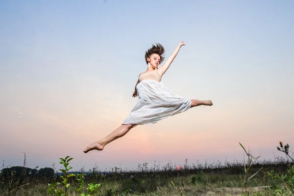 Yang female ballet dancer performs outdoor on sunset. Stock Picture