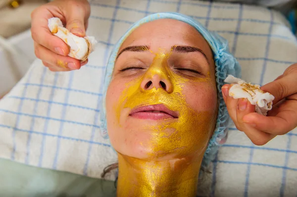 Güzel bir kadınla yüz altın maske Güzellik Salonu. — Stok fotoğraf