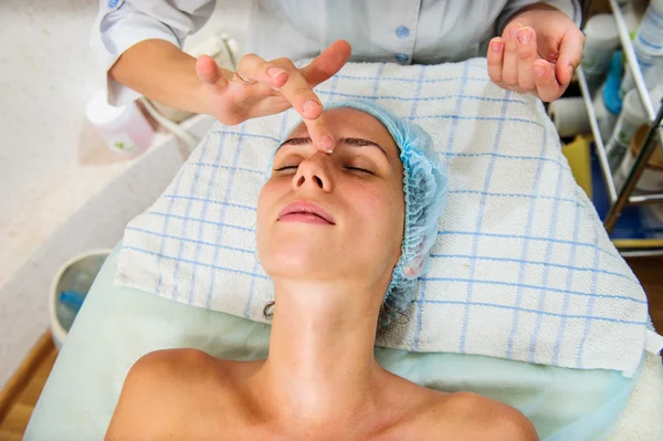 Hermosa mujer con máscara facial dorada en el salón de belleza . — Foto de Stock