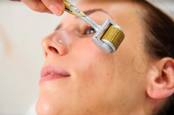 Schöne Frau mit goldener Gesichtsmaske im Schönheitssalon. — Stockfoto