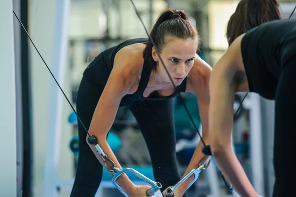 Woman Is working on her chest with cable crossover In gym . — 图库照片