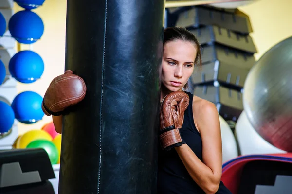 Bella donna sportiva boxe con sacco da boxe rosso in palestra . — Foto Stock