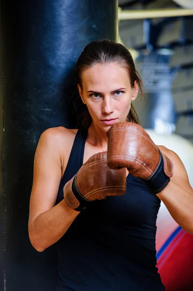 Bella donna sportiva boxe con sacco da boxe nero in palestra . — Foto Stock