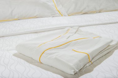 otel yatak üzerinde katlanmış banyo bornoz.